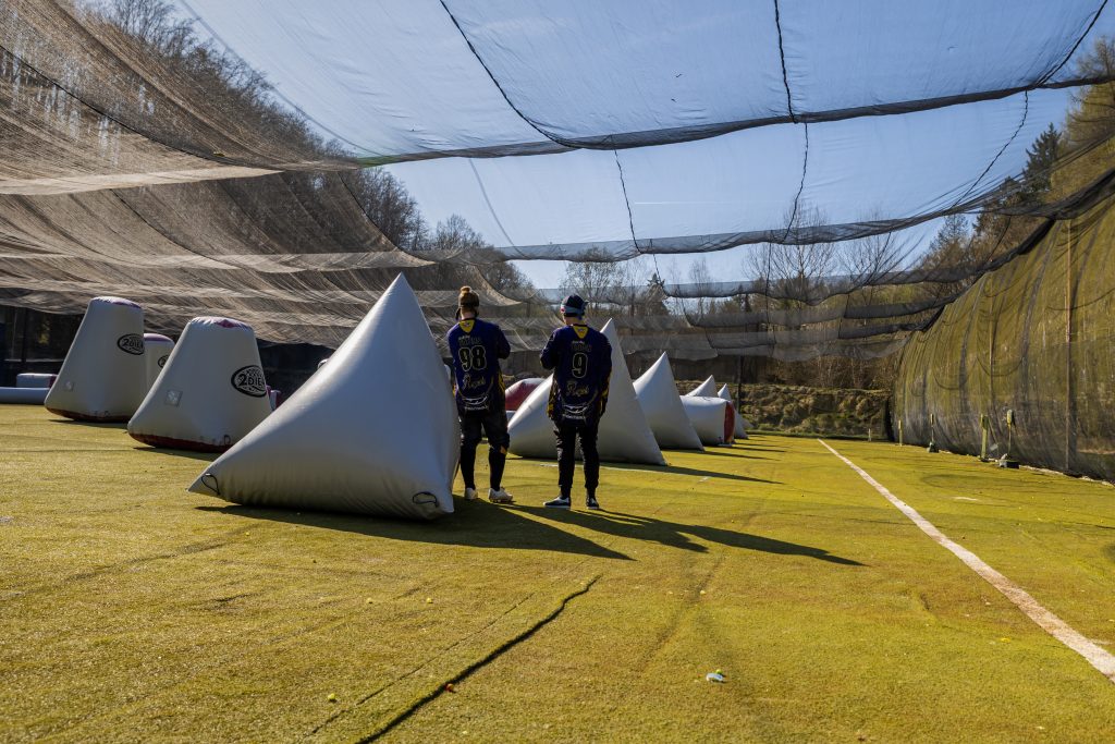 Auf einem Paintballfeld stehen zwei Paintballspieler