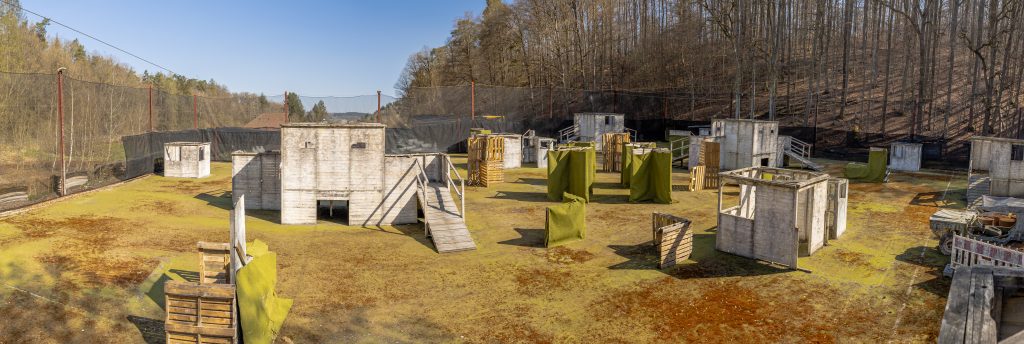 Auf einem Paintballfeld stehen Holzhütten